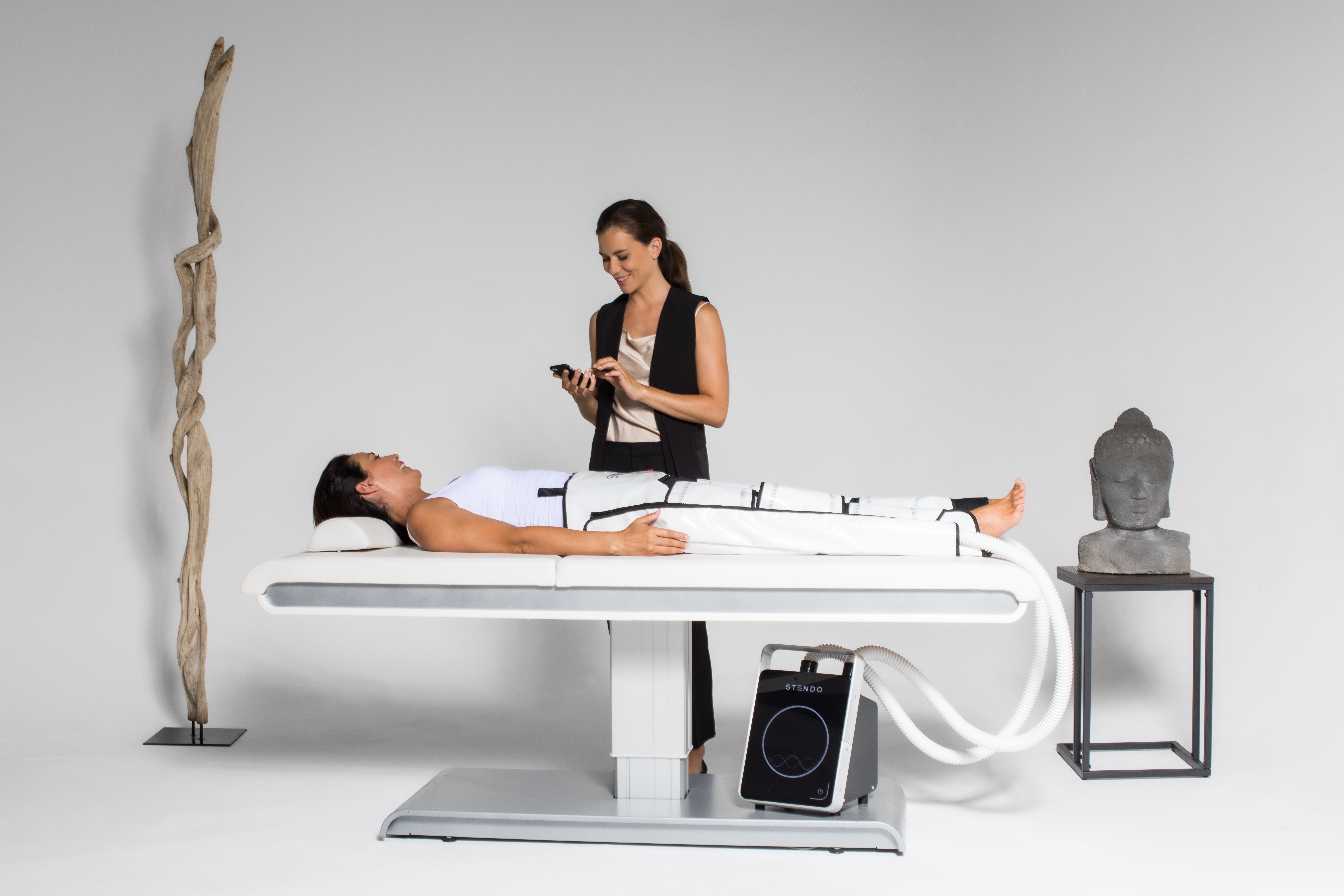 A practitioner running a STENDO BODY V4 vascular-therapy session in a spa setting